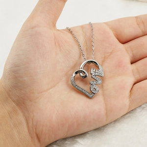 Polished silver heart pendant necklace with LOVE lettering and crystals on white fur