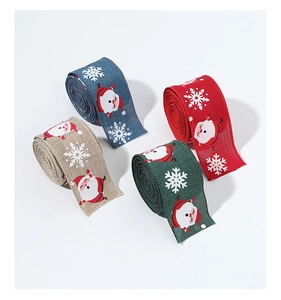 Vue détaillée de rubans de Noël avec imprimés Père Noël et flocons sur faux lin texturé