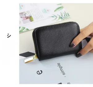 Close-up of black litchi pattern leather wallet with gold zipper detail