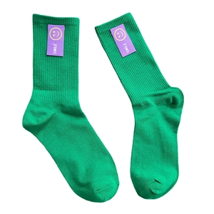 Chaussettes vertes côtelées en coton avec écussons SMILE violets sur fond blanc