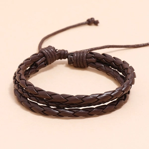 Gros plan sur un bracelet en cuir tressé multicouche marron foncé avec cordon réglable
