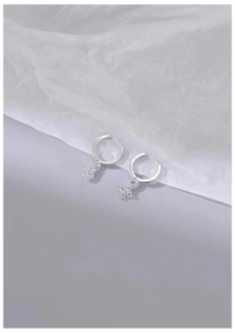 Macro shot of silver flower earrings with marquise-cut zircons and polished hoop clasp