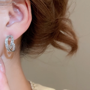 Close-up of double-layer silver C-shape earrings with zircon stones on female model