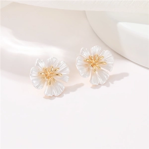 Elegant white camellia and daisy flower stud earrings with 14k gold accents on fabric