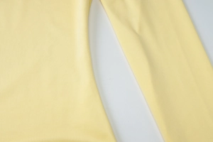 Détail en gros plan des coutures et du tissu en maille jaune clair de cette robe élégante
