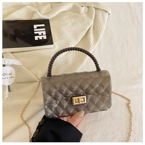 Detail of transparent grey quilted crossbody bag with beaded handle and golden chain