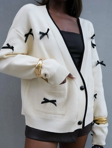 Cardigan chic in maglia crema con fiocchi neri e profili a contrasto per le donne