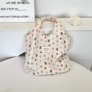 Dettaglio della borsa tote trapuntata con stampe di gatti ed etichetta tessuta colorata