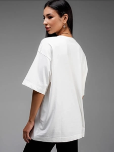 Πλευρική όψη λευκού oversize βαμβακερού t-shirt με πεσμένους ώμους και χαλαρή εφαρμογή