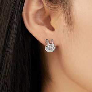 Close-up of a silver bunny stud earring with cubic zirconia worn on an earlobe