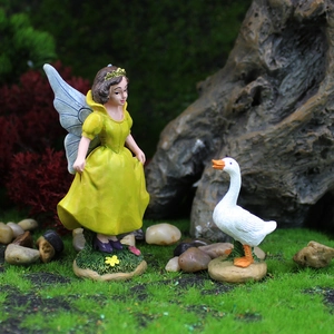 Miniature de fée en robe jaune aux ailes bleues et décorations d'oie de jardin