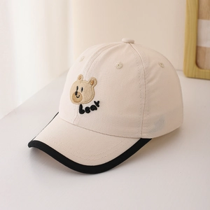 Détail de la casquette de baseball pour bébé avec broderie d'ours et bord noir contrasté