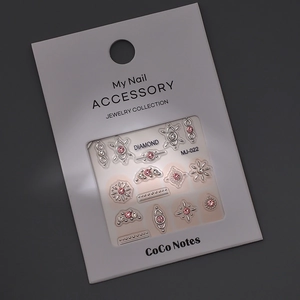 Nail art charms set with silver frames, pink crystals and stars on dark background