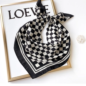 Fashionable black and white checkerboard silk scarf folded on an elegant frame