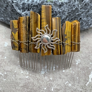 Detailed view of handmade tiger eye crystal hair comb with a central sun charm
