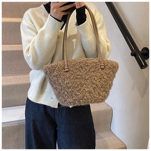 Gros plan d'un sac à main en peluche marron chaud avec texture fausse fourrure et cuir