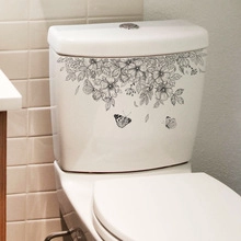 Detail of self-adhesive floral vine and butterfly wall sticker on a white toilet tank