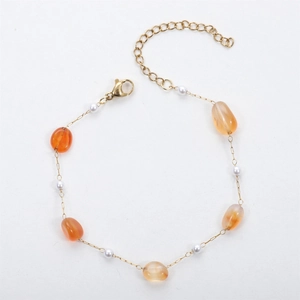 Macro detail of 18K gold-plated chain with orange agate stones and small pearls