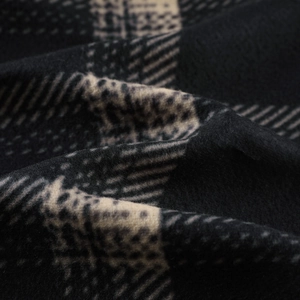 Macro detail of thick checkered flannel fabric showing warm texture and soft fleece material