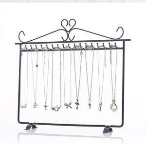 Detail of black metal necklace organizer stand featuring top heart decoration and hooks
