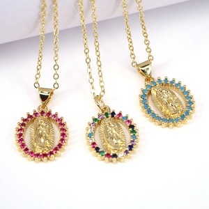 Detailed macro view of three gold-plated Virgin Mary necklaces with colorful crystals