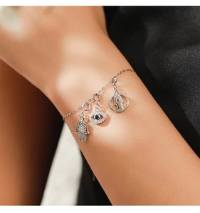 Close-up of 925 silver Evil Eye and Hamsa Hand bracelet on wrist with zircon stones