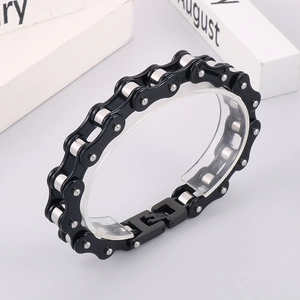Close-up of black and silver stainless steel motorcycle chain bracelet with industrial link