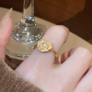 Macro detail of 24K gold plated flower ring with sparkling zircon petals on finger