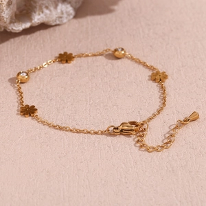 Detail of 18K gold-plated bracelet with flower charm and sparkling diamond-set beads