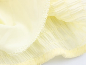 Macro detail of pale yellow seersucker fabric texture and professional hem stitching