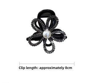 Detail shot of 8cm sunflower hair claw with sparkling rhinestones and white pearl center