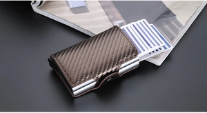 Detail of brown carbon fiber RFID wallet with automatic slide-out silver card mechanism
