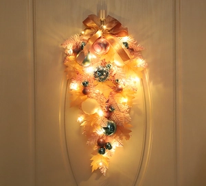 Dettaglio della ghirlanda natalizia rosa con luci LED e fiocco dorato decorativo
