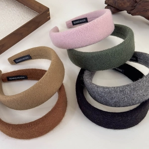 Flat lay of colorful wool fabric wide headbands with handmade tags in six neutral colors