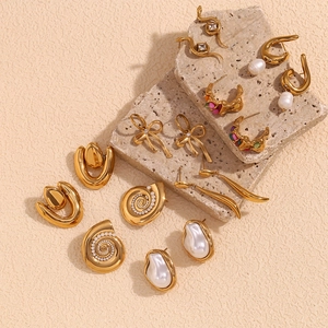 Flat lay of vintage gold irregular earrings set with baroque pearls and rhinestones