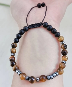 Bracelet perles code Morse avec œil de tigre et cordon noir réglable porté au poignet
