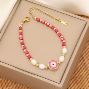 Women beaded bracelet featuring pink evil eye charm and pearls on beige jewelry box