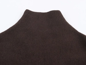 Dettaglio del collo a lupetto su uno scialle in maglia di lana marrone scuro di lusso