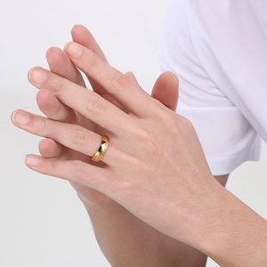 Close-up of polished 18K gold plated stainless steel wide band ring on model's finger