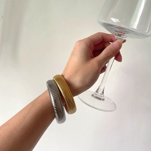 Detail of vintage style gold and silver elastic snake bone bracelets with metallic texture
