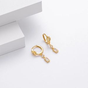 Detail of 925 silver gold star earrings with rectangular zircon drops on white stones
