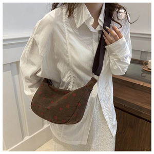 Brown corduroy crossbody bag with red polka dots and wide strap on model
