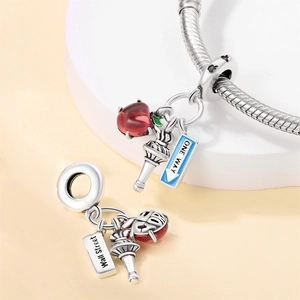 Silver snake chain bracelet with New York themed charms including red apple and Wall Street signs