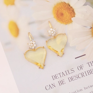 Detailed view of yellow heart-shaped earrings with zircon accents and gold plating