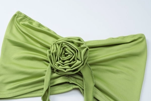 Detailed close-up of grass green satin rose floral accessory with layered fabric texture