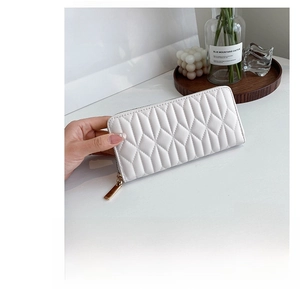 Macro detail of white quilted PU leather long wallet with premium gold zipper finish