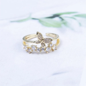 Golden double butterfly open ring with sparkling cubic zirconia on white background