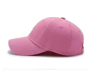 Side view of bright pink cotton baseball cap with curved brim and detailed stitching