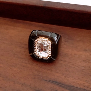Macro shot of vintage resin ring with square crystal and gold setting on wood