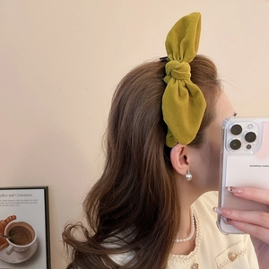 Macro shot of mustard yellow velvet bow headband on model for high skull top hair look